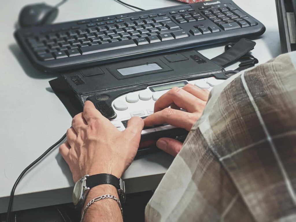 Image d'une main en train d'utiliser un clavier outil braille pour accéder au contenu numérique de manière accessible grâce à l'accessibilité numérique